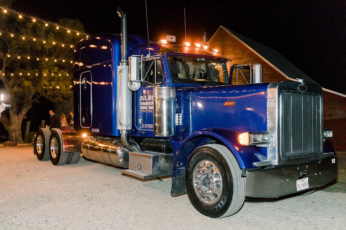 Blue Bilbo Peterbilt lit up at night under string lights
